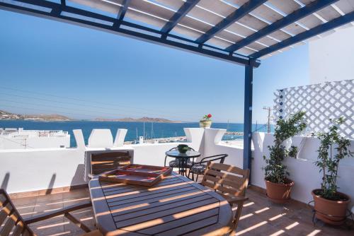 a patio with a table and chairs and the ocean at Katerina Rooms in Naousa