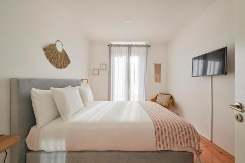 a bedroom with a large white bed with a window at Lisbon Lodge 2# in Lisbon