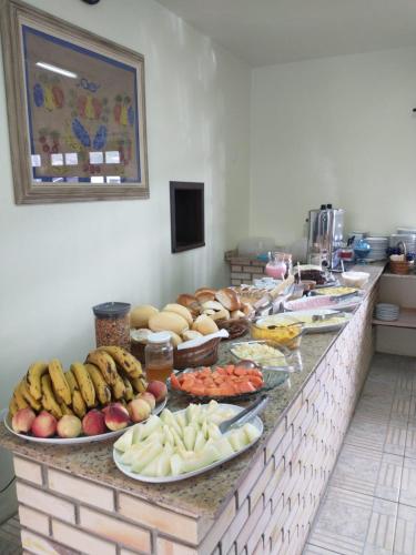 Una línea de buffet con platos de frutas y verduras. en Pousada Baleia Franca, en Garopaba