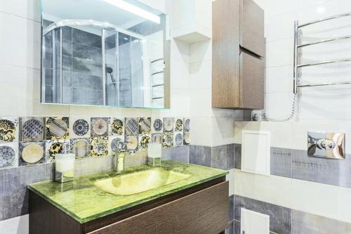 y baño con lavabo y espejo. en Панорамный вид 15 этаж. Набережная Днепра, en Kiev