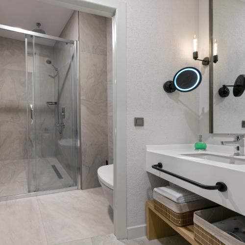 a bathroom with a shower and a sink and a toilet at A Suite Side in Side