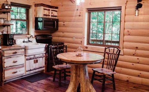 a kitchen with a table and chairs in a cabin at Treehouse #8 by Amish Country Lodging in Millersburg