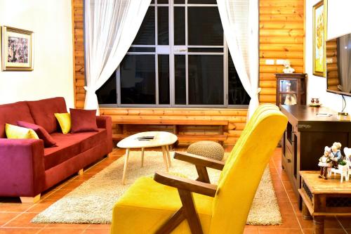 a living room with a red couch and a yellow chair at אוויר הרים in Kefar Weradim