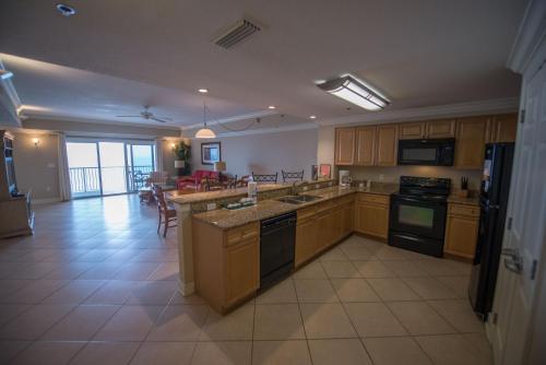 a large kitchen with wooden cabinets and a dining room at Escapes! To The Shores Orange Beach, A Ramada by Wyndham in Orange Beach