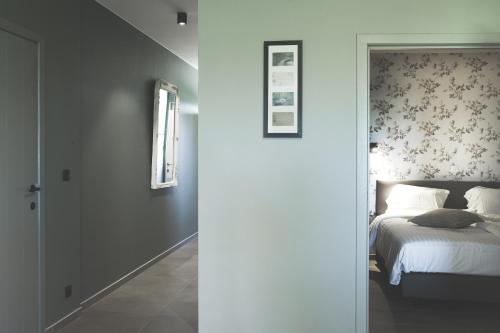 - une chambre avec un lit et un mur avec un miroir dans l'établissement Vakantiehuis NIEUWHOF, à Gistel