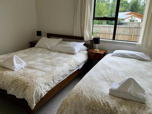 2 camas en un dormitorio con ventana en 42 Scarborough Tce, en Hanmer Springs