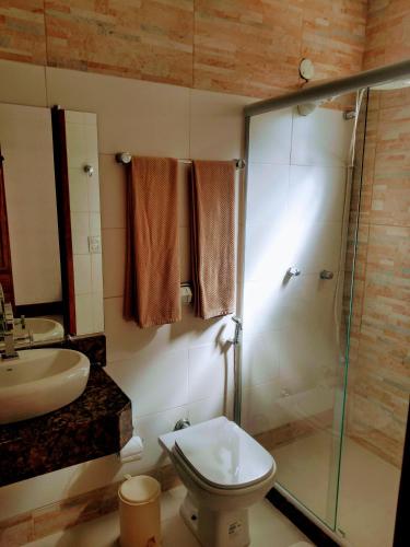a bathroom with a shower and a toilet and a sink at 3 Palmeiras Guest Lounge in Miguel Pereira