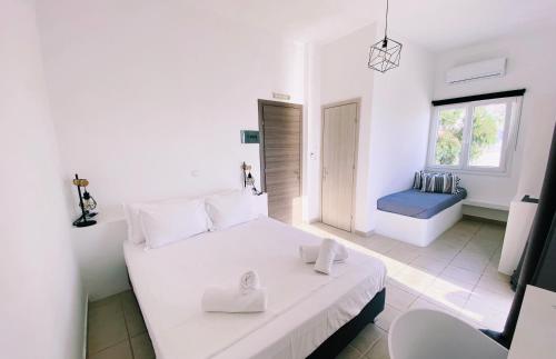 パリキアにあるAlkyon Hotelの白いベッドルーム(ベッド1台、バスルーム付)
