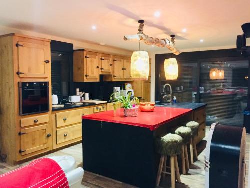 une cuisine avec un îlot rouge au milieu dans l'établissement Mon Petit coin de Paradis, à Verlincthun