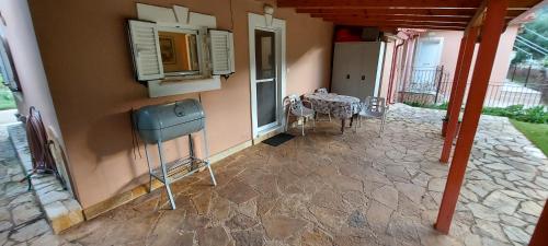 a house with a patio with a table and a window at The Seasons of Nickolas in Ayia Evfimia