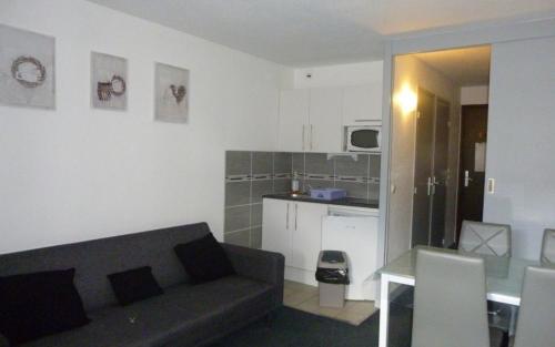 un salon avec un canapé et une table et une cuisine dans l'établissement Appartement au pied des pistes, à Les Deux Alpes