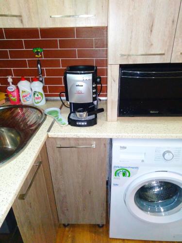 a coffeemaker sitting on a kitchen counter next to a washing machine at Dom Semya Deluxe Gusar in Qusar