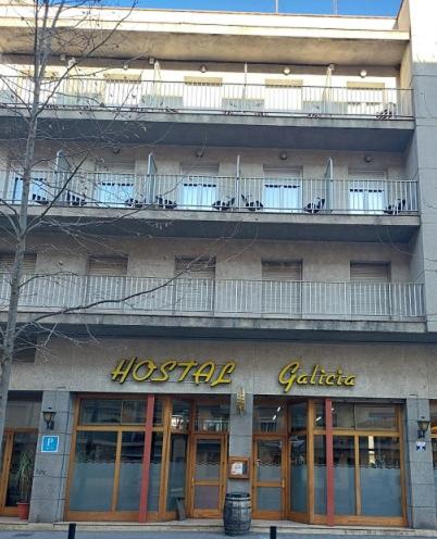 um edifício de hostel com uma varanda em cima em Hostal Galicia em Figueres