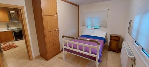 a small bedroom with a bed and a kitchen at The Seasons of Nickolas in Ayia Evfimia
