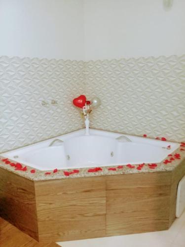 a bath tub with a red heart on top of it at Hotel Pousada Riacho da Areia in Águas de Lindóia