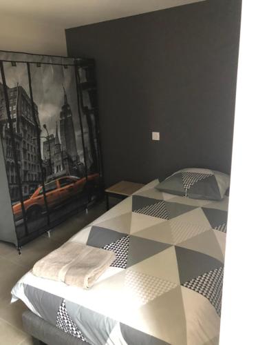 1 dormitorio con 1 cama y una pintura en la pared en Gîte Le Marronnier - La Planhe, en Bozouls
