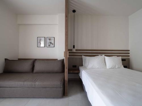 a bedroom with a bed and a couch at Asimina Suites in Nikiti