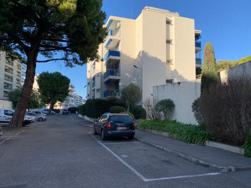 une voiture garée dans un parking à côté d'un bâtiment dans l'établissement Superbe Studio en résidence proche de la Mer, à Cagnes-sur-Mer