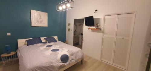 a bedroom with a large bed with blue walls at LE MANGUIER in Baie-Mahault