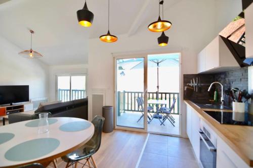Il comprend une cuisine et un salon avec une table et des chaises. dans l'établissement Coco Elaura Modern Duplex with 2 Bedrooms and a Balcony in Biarritz, à Biarritz