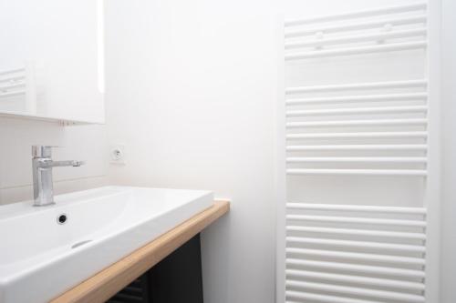 a white bathroom with a sink and a shower at 203 Duplex Jeanne d'Arc in Toulouse