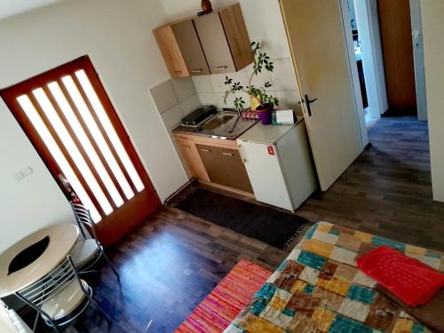a small kitchen with a refrigerator and a table at Sanja Accomodation in Soko Banja