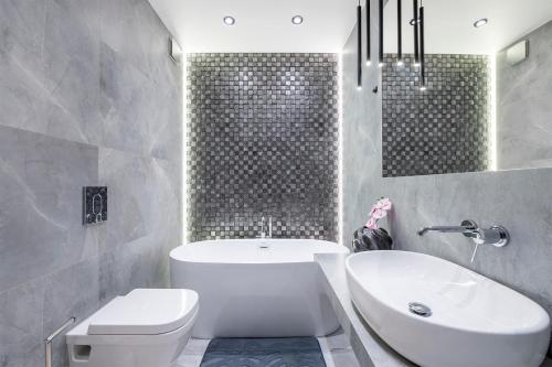 Manufaktura's STAR ***** apartment by PinPoint في لودز: حمام مع حوض ومرحاض ومغسلة