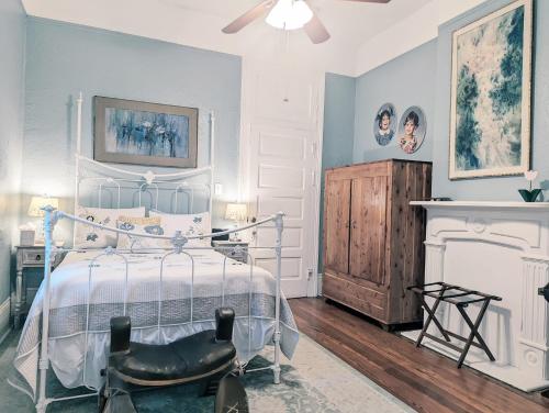 a bedroom with a bed and a chair and a fireplace at Royal Sunshine in New Orleans