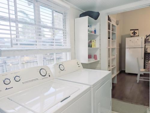 a white laundry room with a washer and dryer at Royal Sunshine in New Orleans
