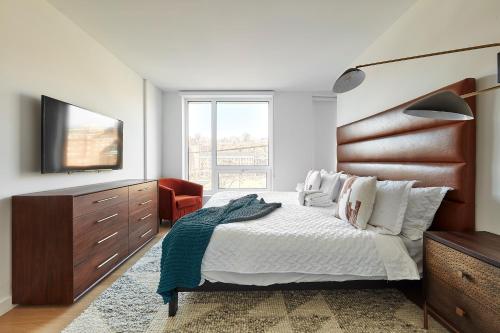 ホーボーケンにあるHarmony Lofts on Jackson 2のベッドルーム(ベッド1台、ドレッサー、テレビ付)