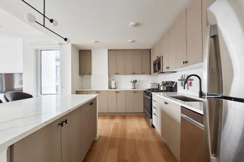 a kitchen with white cabinets and a white counter top at Harmony Lofts on Jackson 2 in Hoboken
