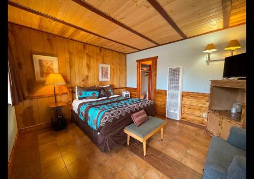 a bedroom with a bed and a chair in a room at West Winds Lodge in Ruidoso