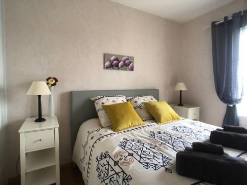 una camera da letto con letto e cuscini gialli di Normandy Confort - WIFI & CALM - Bayeux Centre a Bayeux
