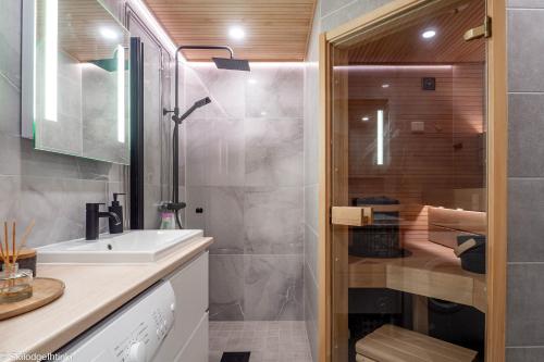La salle de bains est pourvue d'un lavabo et d'une douche. dans l'établissement RUKA Skilodge Ihtinki, two bedrooms (Free Wi-Fi), à Ruka