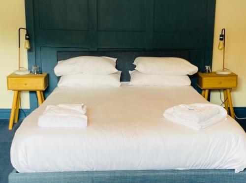 The Wilcove Inn في توربوينت: سرير ابيض كبير عليه منشفتين