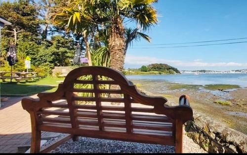 a person sitting on a bench near a body of water at The Wilcove Inn in Torpoint