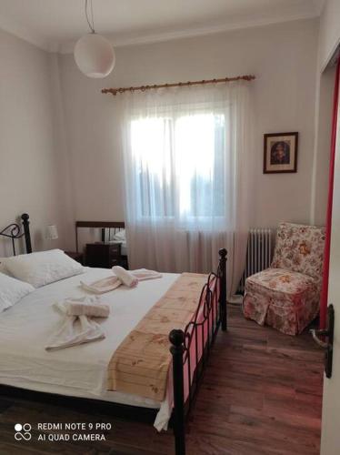 a bedroom with a bed and a chair and a window at Diktynna villa in Palekastron