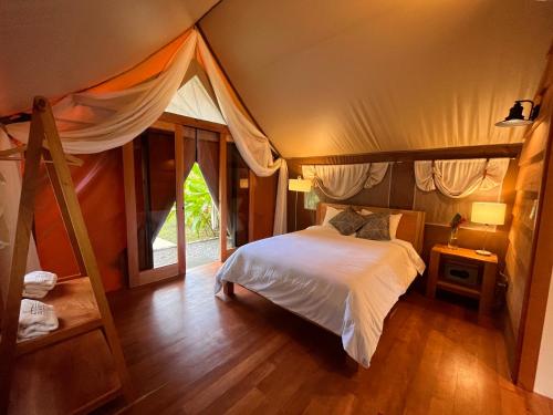 a bedroom with a bed in a tent at Hotel Arenal Glamping in Fortuna