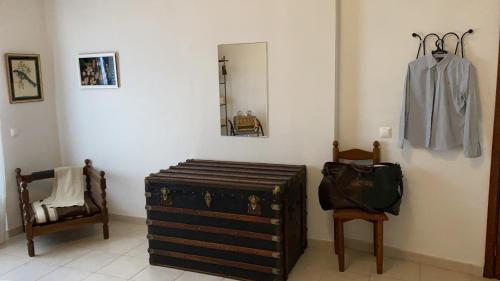 a room with a suitcase and a mirror and a chair at Os 5 Sentidos in Mourão