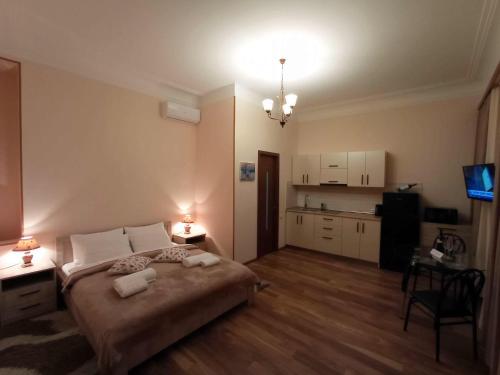 a bedroom with a large bed and a kitchen at La Maison #7 in Tbilisi City