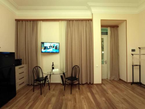 a living room with a table and chairs and a television at La Maison #7 in Tbilisi City