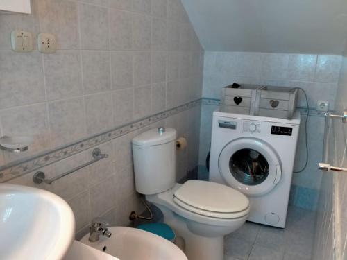 a bathroom with a toilet and a washing machine at Casa Bella in Siracusa
