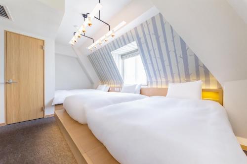 two beds in a room with a staircase at The Happo by HHG in Hakuba