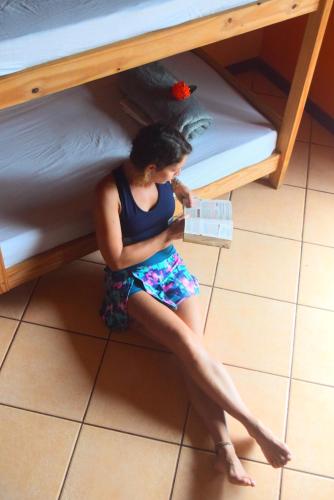 a man sitting on the floor under a bunk bed at Leo's Clan Beach Hostel in Paraty
