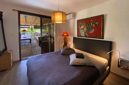 ein Schlafzimmer mit einem großen Bett mit einer Lampe in der Unterkunft Habitation gens bois in Le Diamant