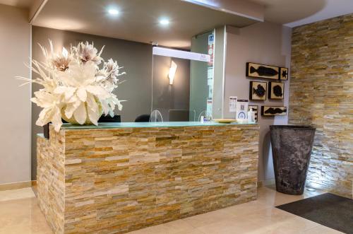 a lobby with a stone counter with a flower centerpiece at Hotel Bocage in Setúbal