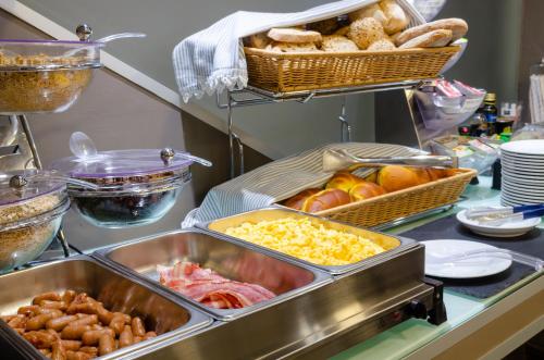un buffet con muchas bandejas de comida en un mostrador en Hotel Bocage, en Setúbal
