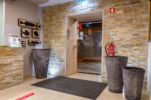 eine Lobby mit zwei großen Vasen vor einer Tür in der Unterkunft Hotel Bocage in Setúbal