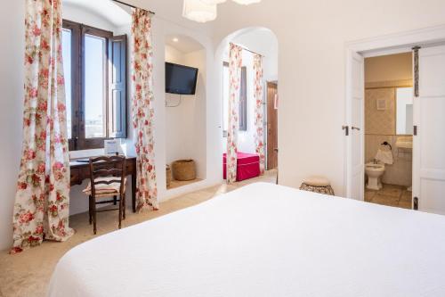 a bedroom with a bed and a desk in a room at Masseria Agrituristica Lama San Giorgio in Rutigliano