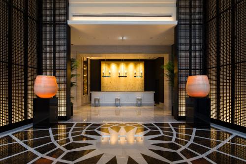 a lobby of a hotel with two lights on the wall at Premier Hotel CABIN PRESIDENT Osaka in Osaka